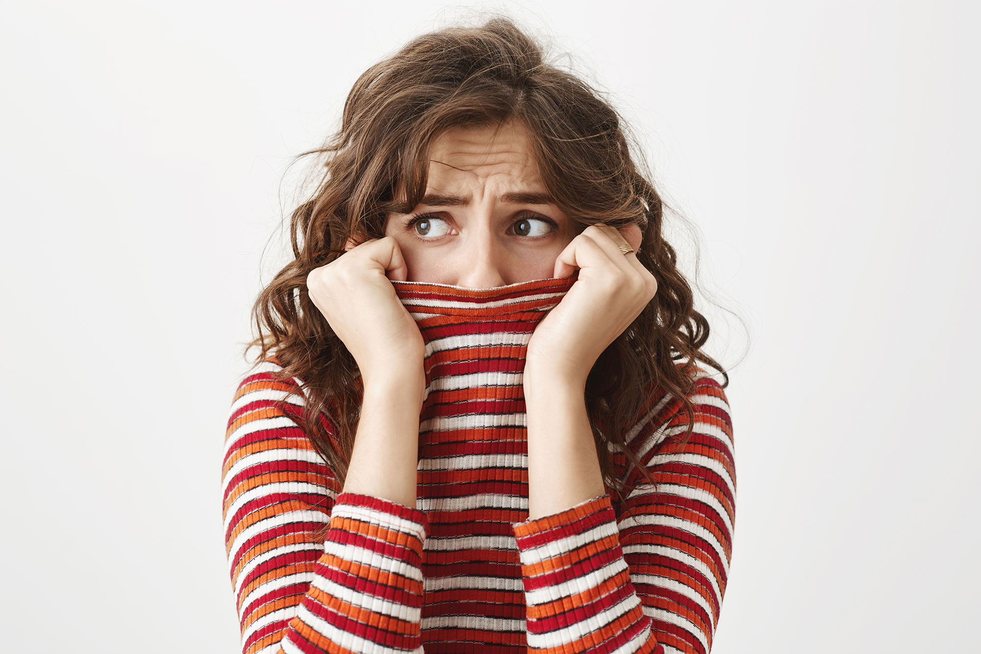 femme inquiète, se cachant derrière son pull 